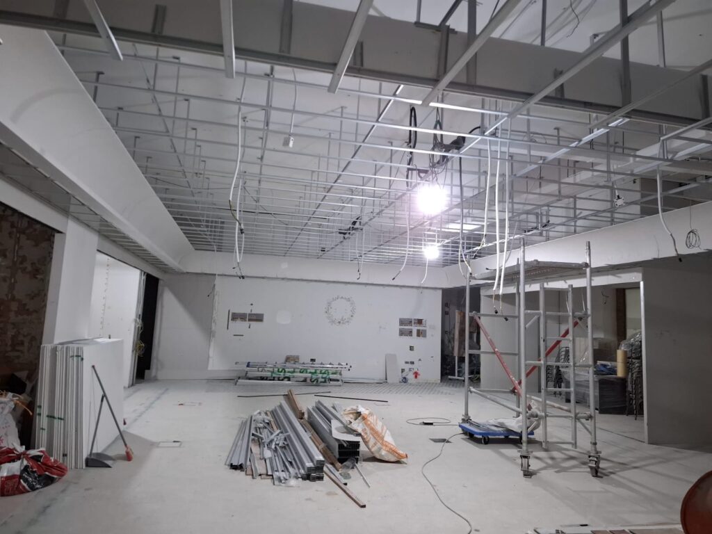 False ceiling contractor installing suspended ceiling in retail shop